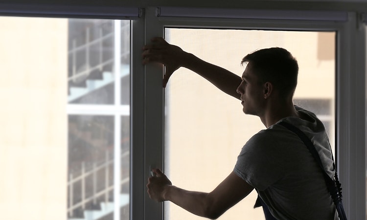 Silhouette of man cleaning large window glass